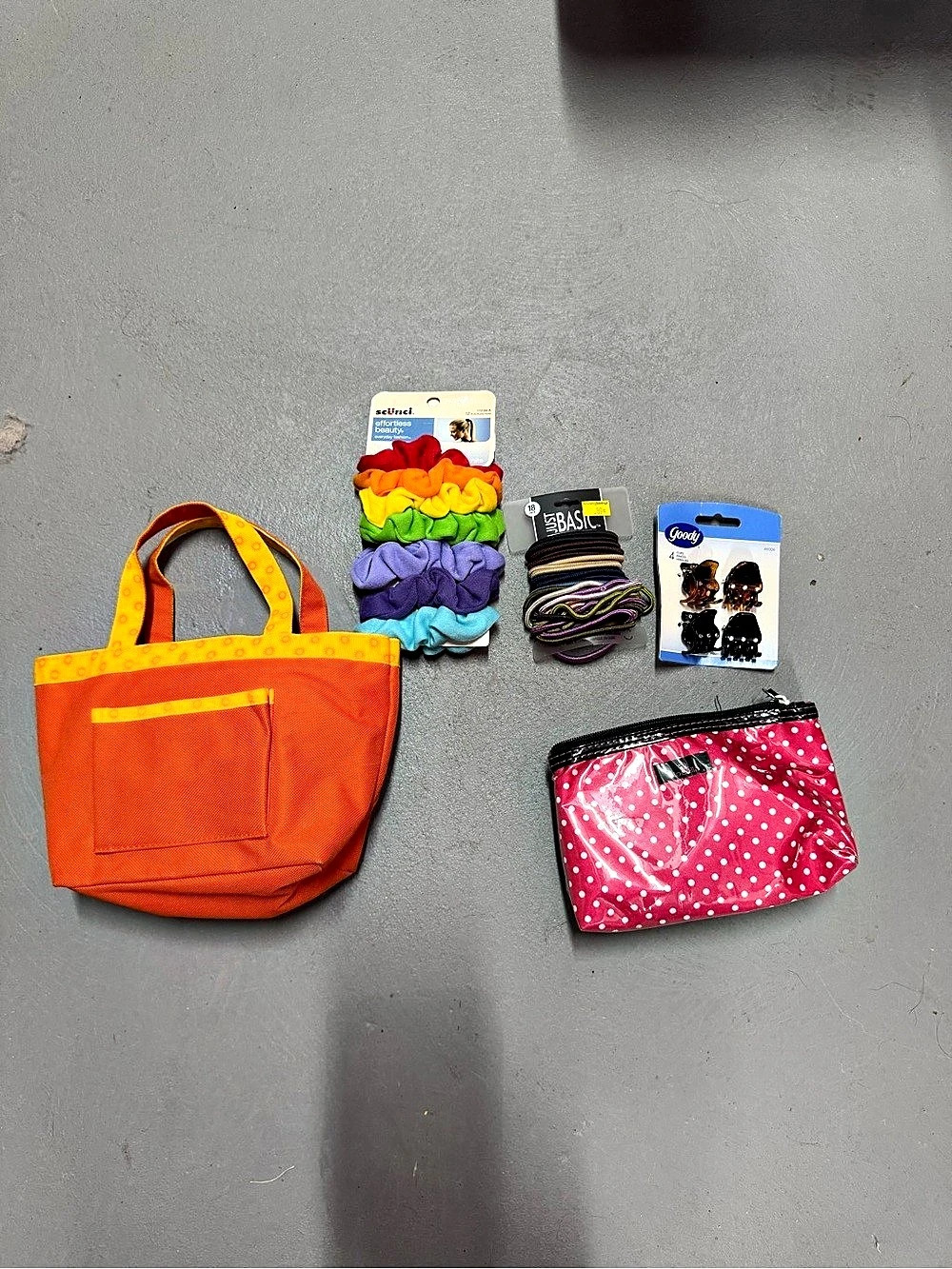 Orange tote bag with pink polka dot pouch and hair accessories